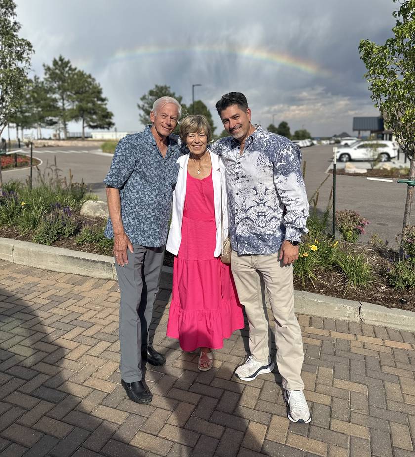 Chad Burmeister with family beneath a rainbow in Colorado